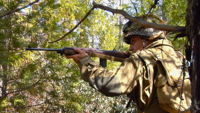 Dan dressed in a WWII uniform ready to fire his rife